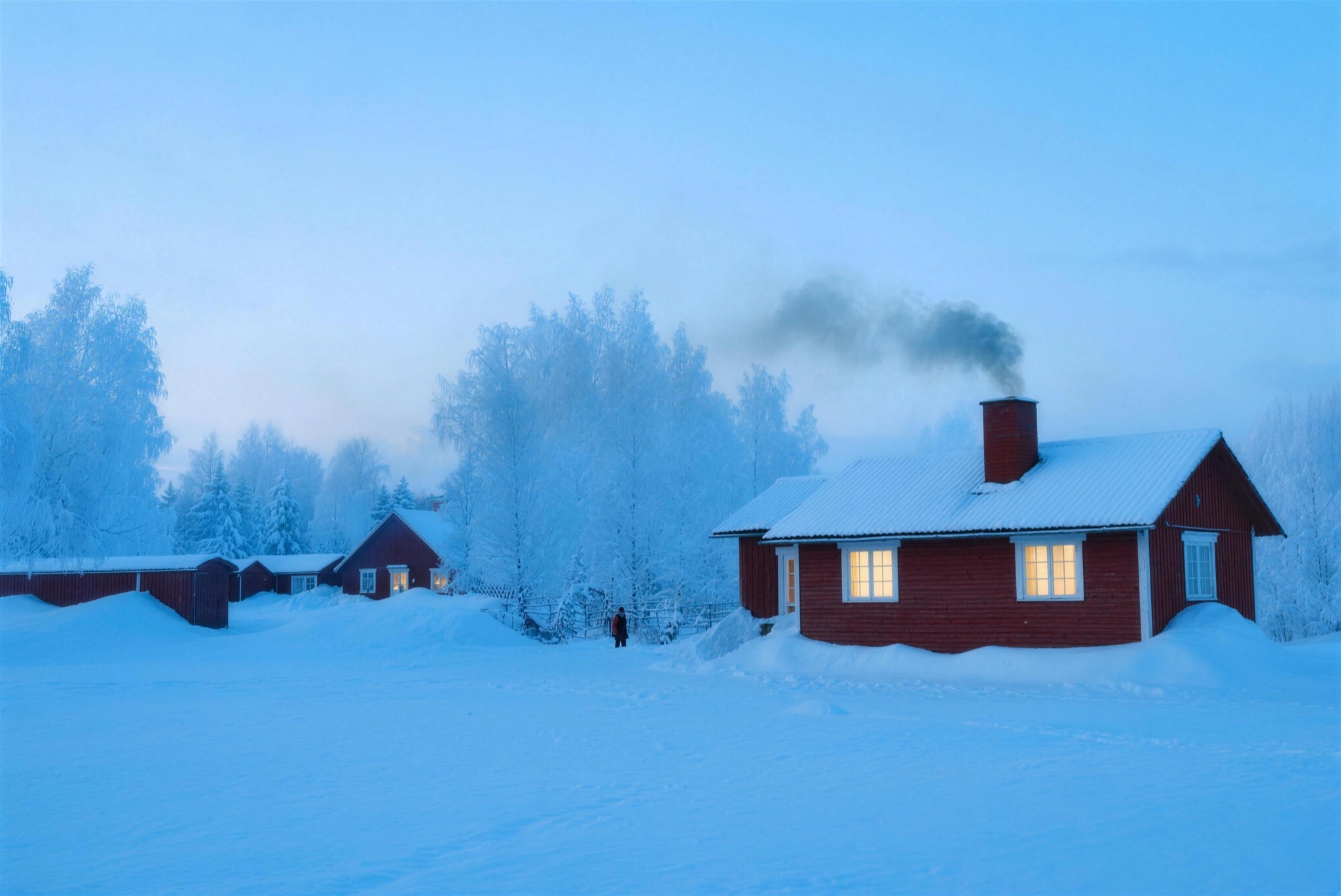 A red wooden house in deep snow