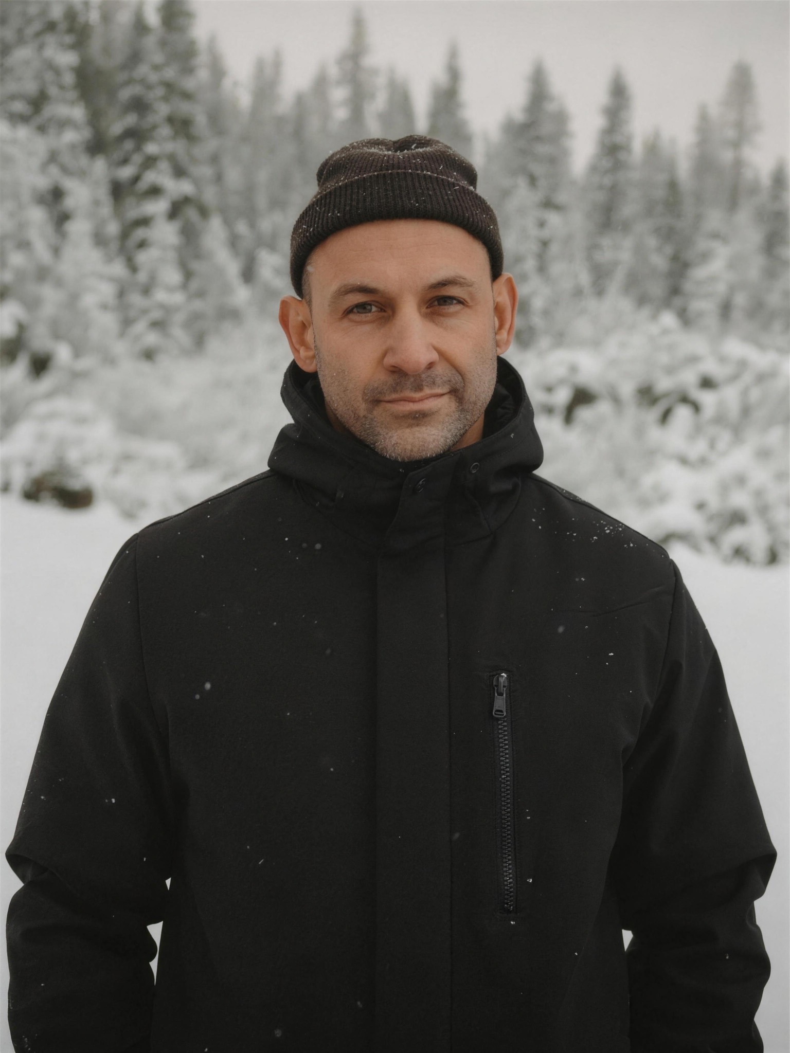 The photographer in the snowy forest beneath the aurora