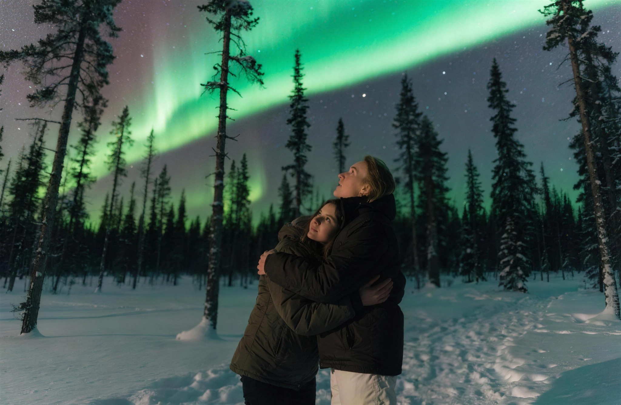 A couple beneath the northern lights of Swedish Lapland
