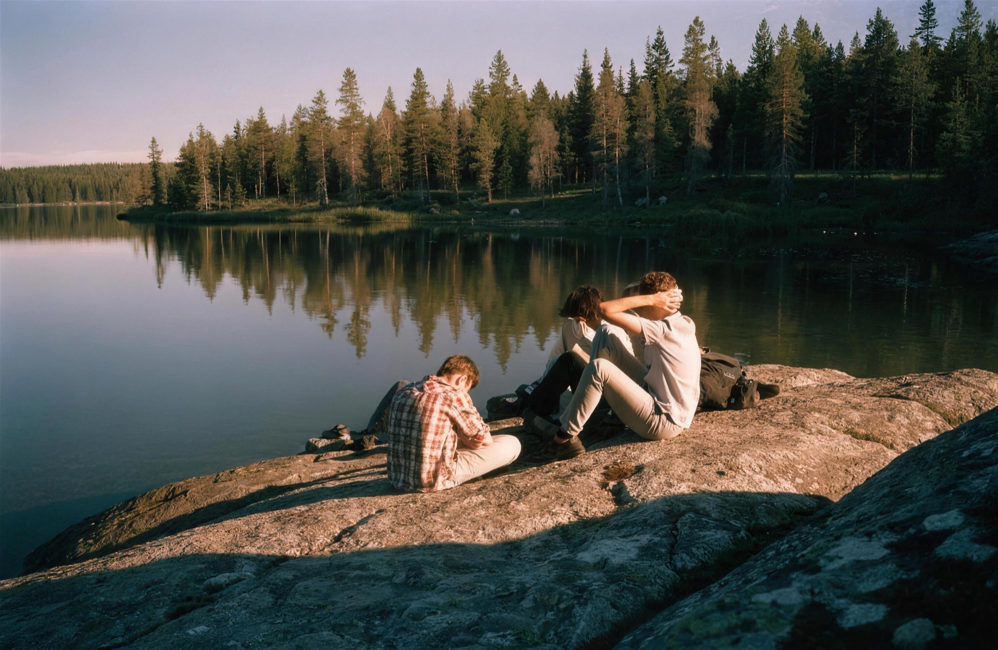 Friends by the lake in the midnight sun