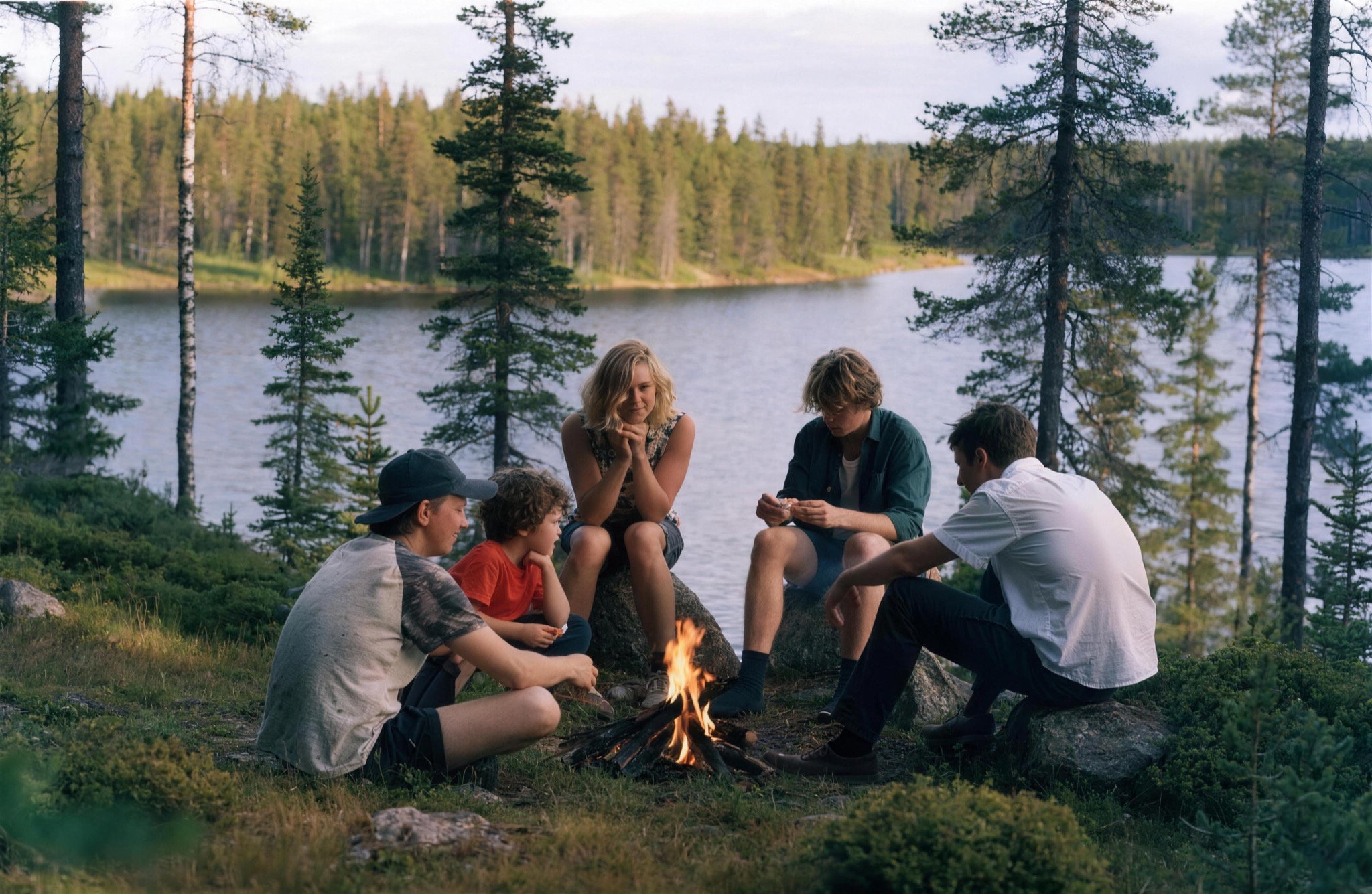 A family by a lakeside campfire in summer