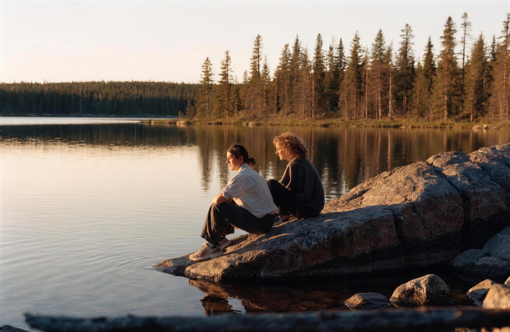 A couple by the lake at golden hour